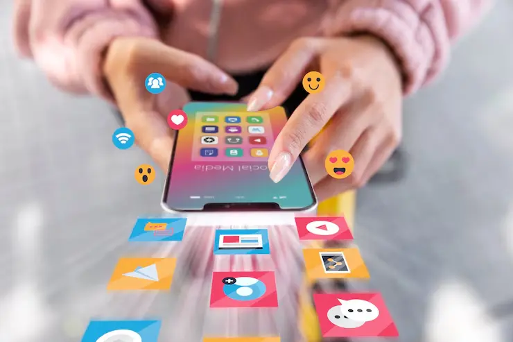 A person using a mobile phone to search for social media marketing, with emojis like hearts and likes on the screen – showing work by the best social media marketing agency in Dubai UAE